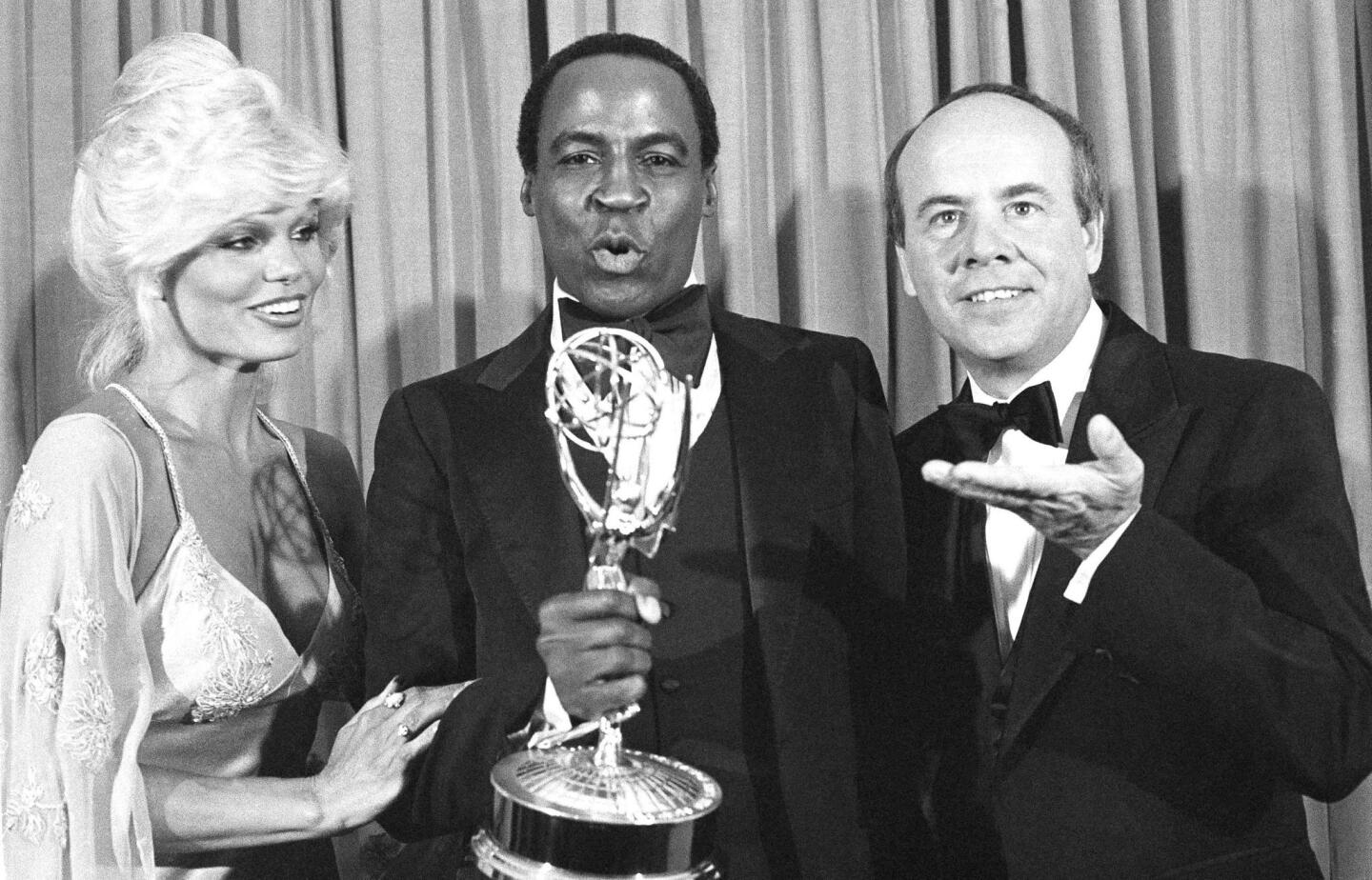 Guillaume, center, accepts his Emmy Award for supporting actor in a comedy-variety or music series for his role in "Soap" from Tim Conway, right, and Loni Anderson at the 31st Emmy Awards in Los Angeles on Sept. 10, 1979.