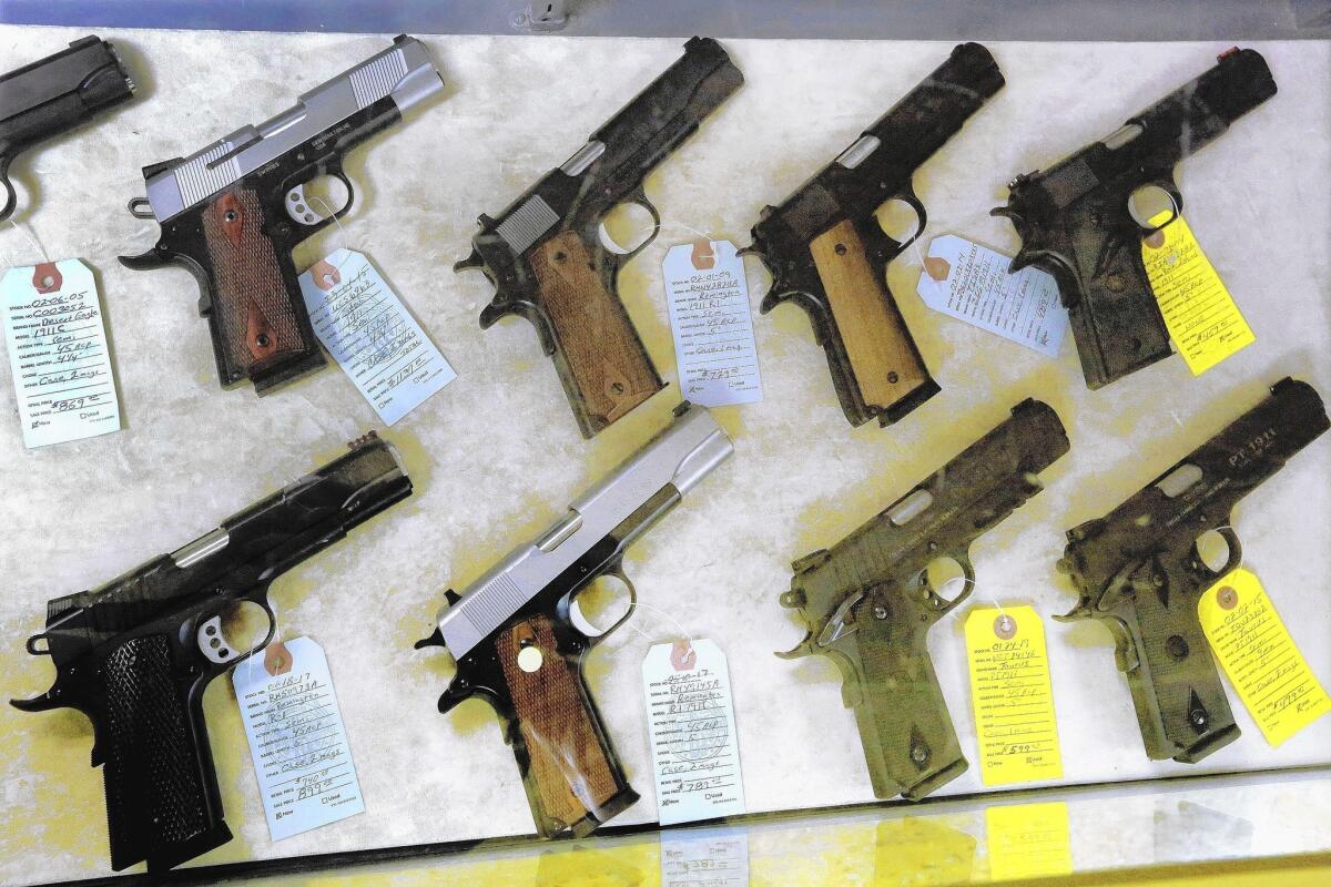 Semi-automatic handguns are seen display for purchase at Capitol City Arms Supply in Springfield, Ill.