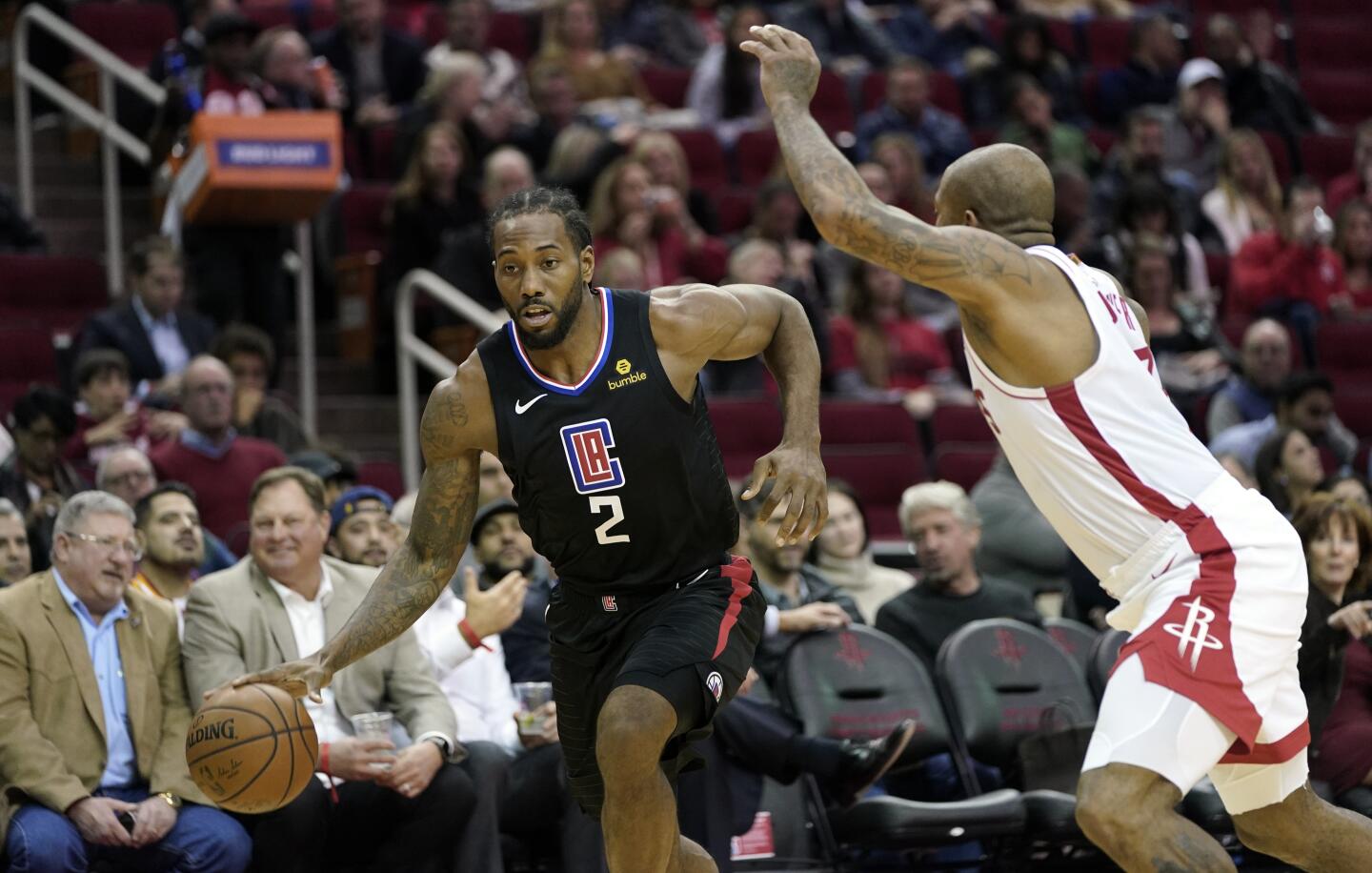 Clippers forward Kawhi Leonard (2) drives to the basket against Rockets forward PJ Tucker during the first half of a game Nov. 13.