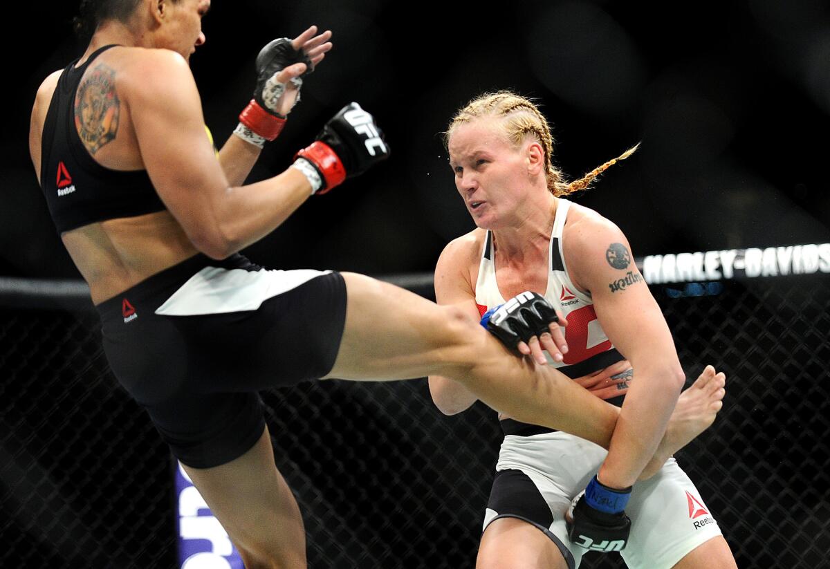 Amanda Nunes, left, has a kick blocked by Valentina Shevchenko during their UFC 196 women's bantamweight fight.