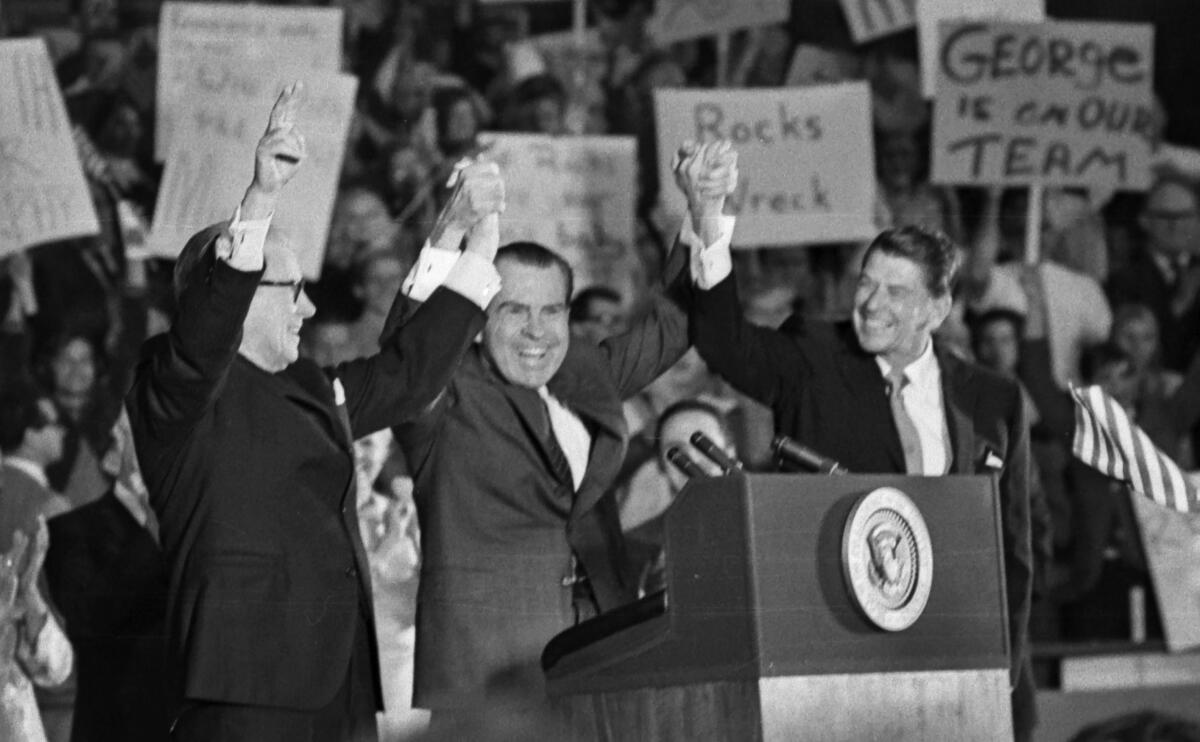 Oct. 30, 1970: President Nixon clasps hands with Gov. Ronald Reagan and Sen. George Murphy at Republican rally in Anaheim.