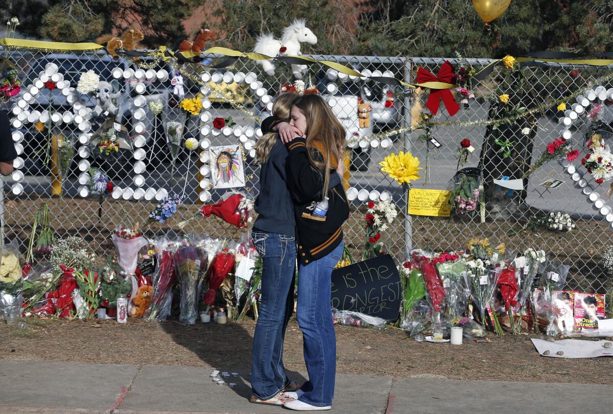 Arapahoe High School students hug at a tribute site honoring senior Claire Davis, who was hospitalized after being shot in the head by a fellow student Dec. 13. Davis died Saturday afternoon.