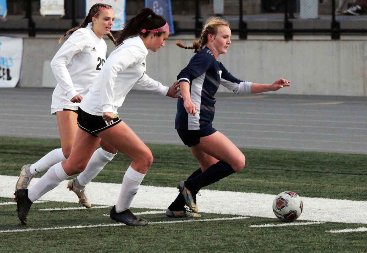 Newport Harbor's Brielle Benedict (9) gets past Capistrano Valley defenders and dribbles down field on Wednesday.