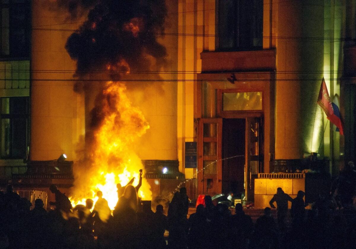 Pro-Russia protesters burn tires near a regional administration building in Kharkiv, Ukraine, in a clash with riot police for control of the building.