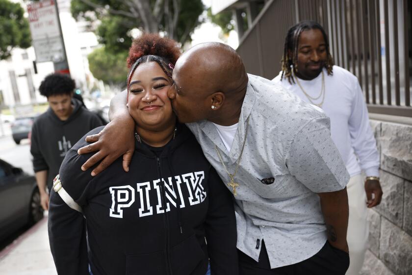 LOS ANGELES-CA-FEBRUARY 27, 2024: Jofama Coleman, right, who served 18 years in prison for a crime he didn't commit, kisses his 19-year-old daughter Jocelyne outside Clara Shortridge Foltz Criminal Justice Center in downtown Los Angeles after he was exonerated on February 27, 2024. (Christina House / Los Angeles Times)