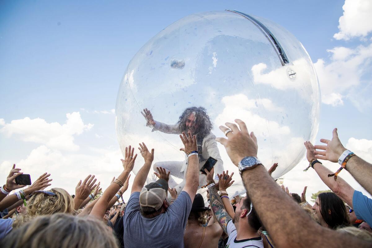 The Flaming Lips' Wayne Coyne crowd-surfs inside a bubble at a festival in 2019. 