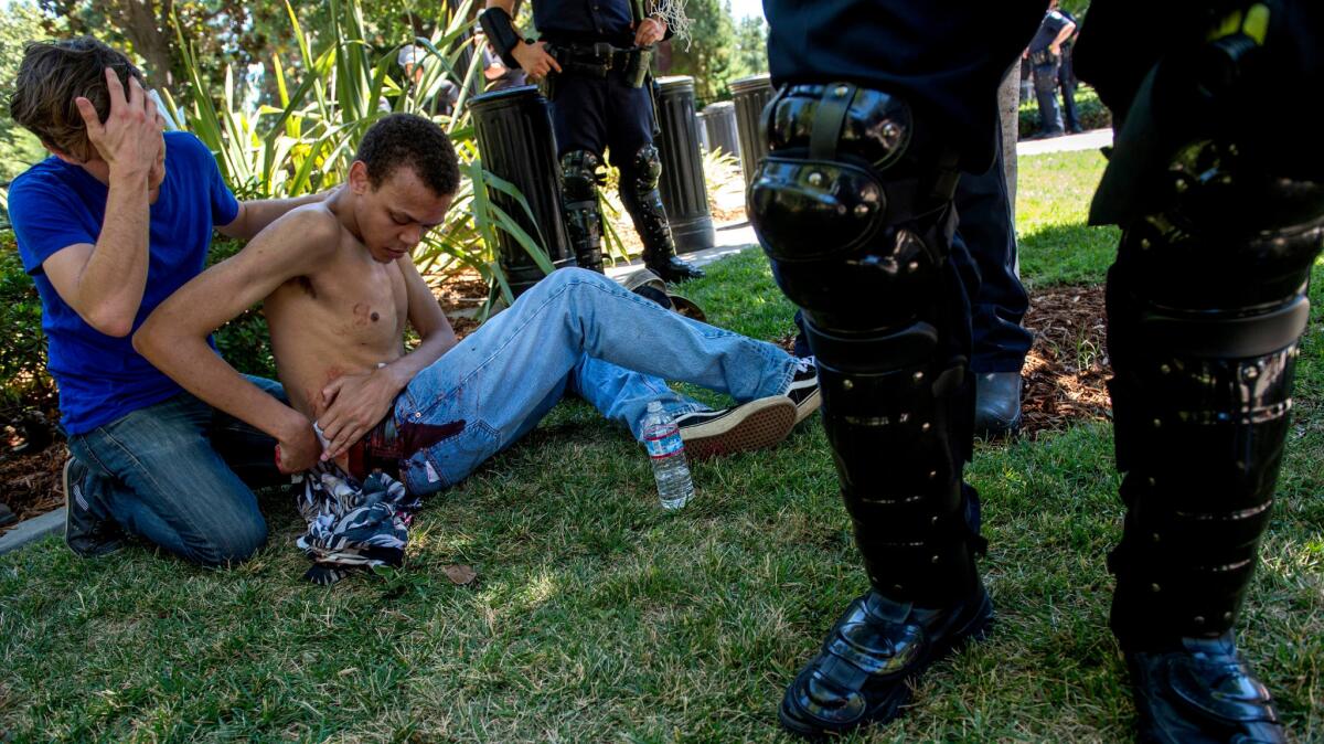 A 23-year-old Sacramento resident waits for medics after being stabbed at Sunday's rally.