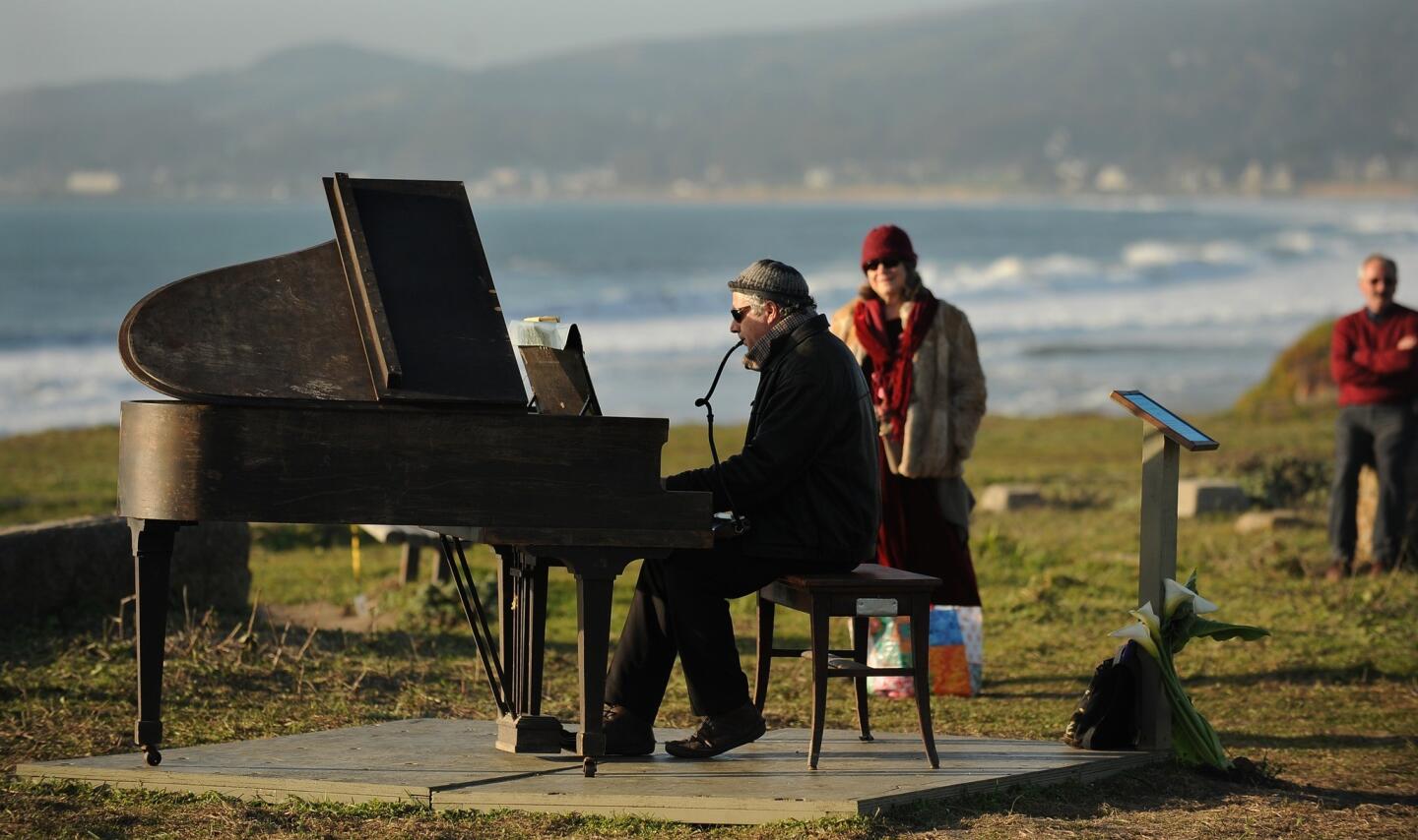 Artist Mauro Ffortissimo plays the piano for a crowd in Half Moon Bay. The piano has been perched overlooking the ocean, and city officials have given Ffortissimo until Thursday to remove it.