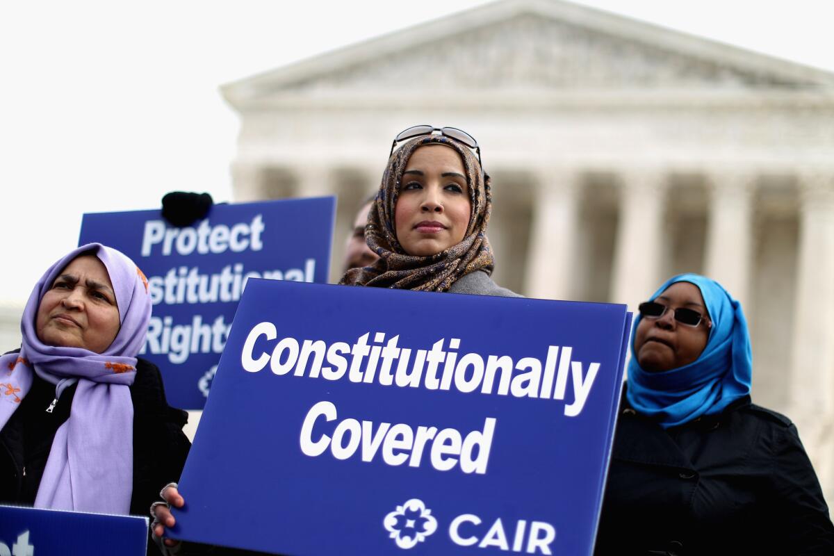 Demonstrators with the Council on American-Islamic Relations stand in support of the organization during a news conference outside the U.S. Supreme Court.