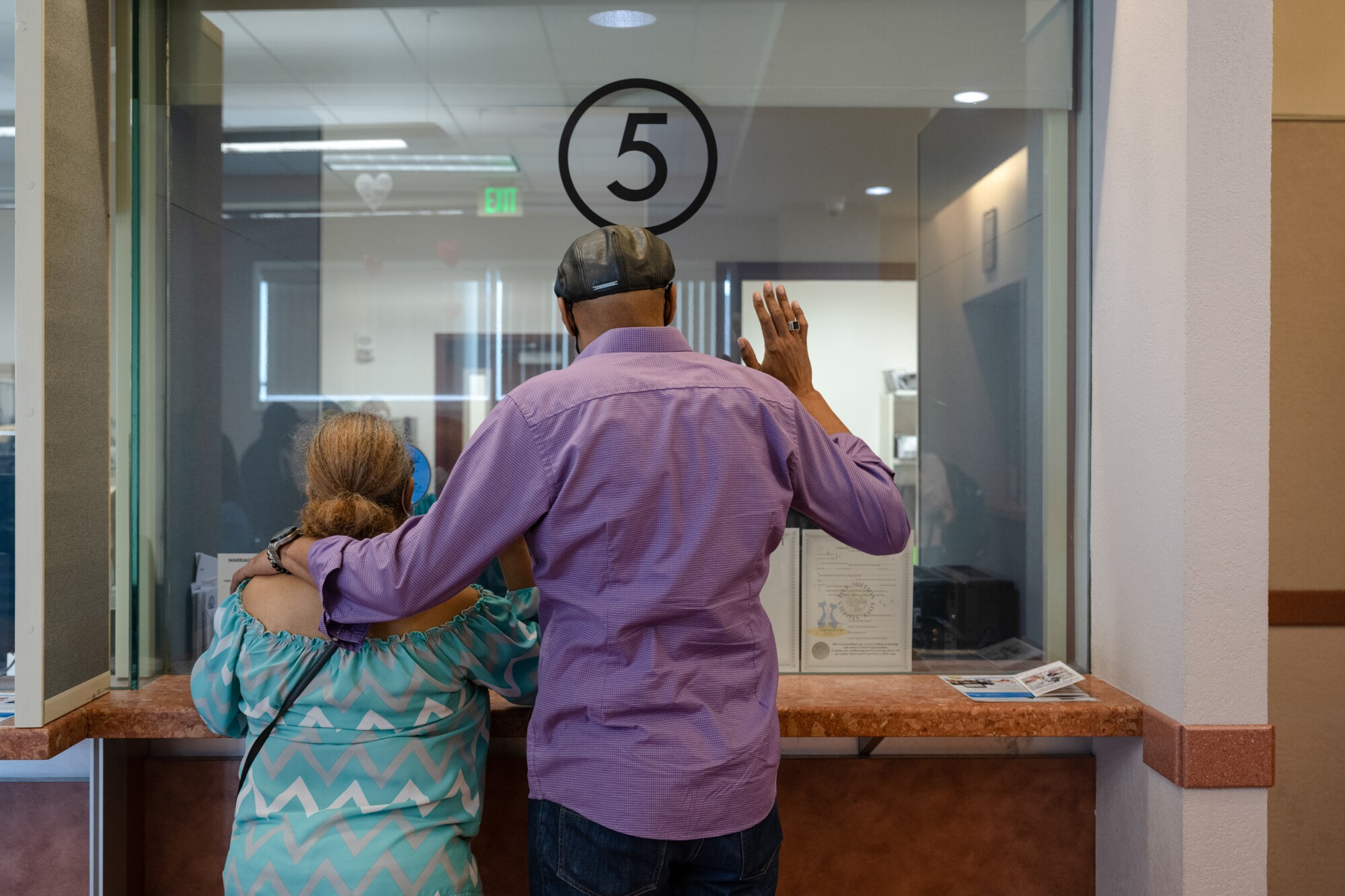 Two people stand at window number five