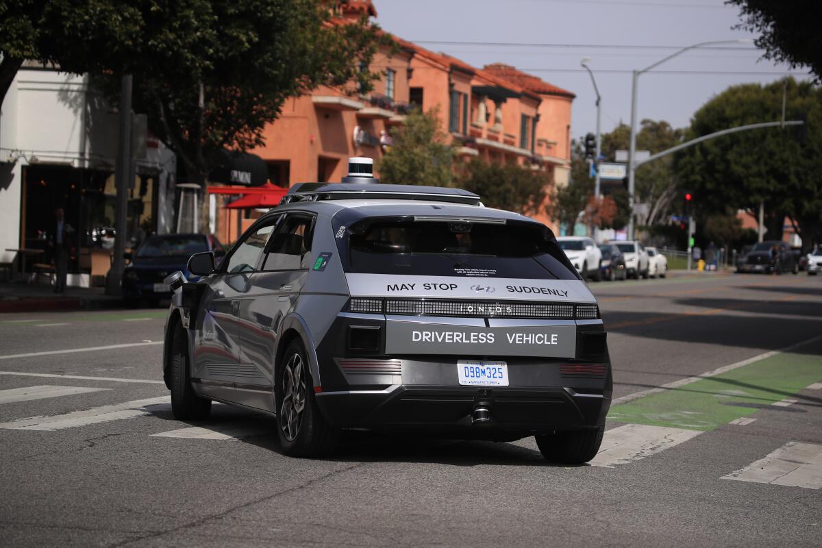 A car outfitted with autonomous vehicle technology makes a turn on a city street. 