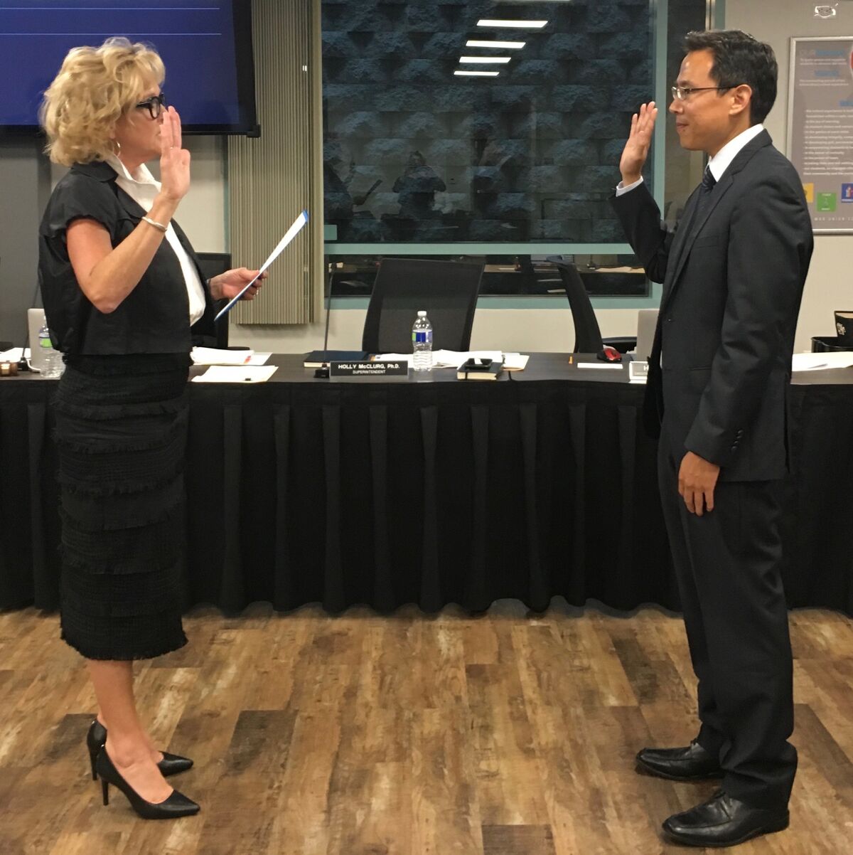 Superintendent Holly McClurg issues the oath of office to Gee Wah Mok.