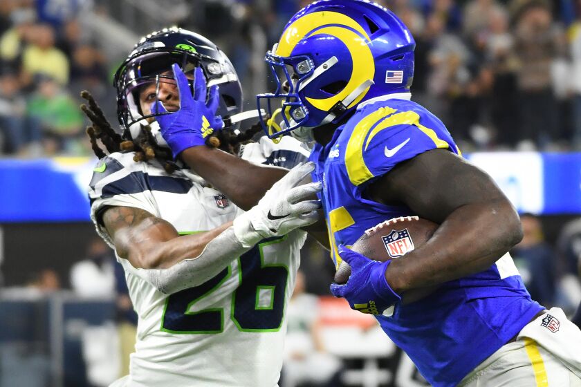 Inglewood, California December 21, 2021: Rams running back Sony Michel stiff-arms Seahawks safety Rayan Neal during a big gain in the third quarter at SoFi Stadium Tuesday in Inglewood. (Wally Skalij/Los Angeles Times)