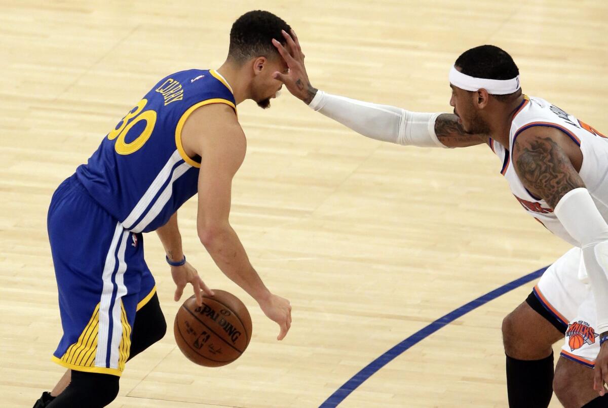 New York Knicks forward Carmelo Anthony puts his hand on the forehead of Golden State guard Stephen Curry.