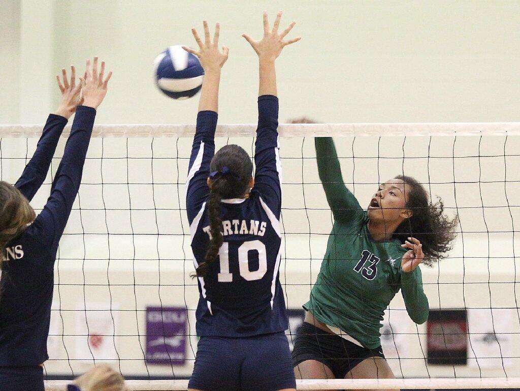 Sage Hill School's Amiyah De'Long, right, kills a ball past two St. Margaret's outside blockers on Tuesday.