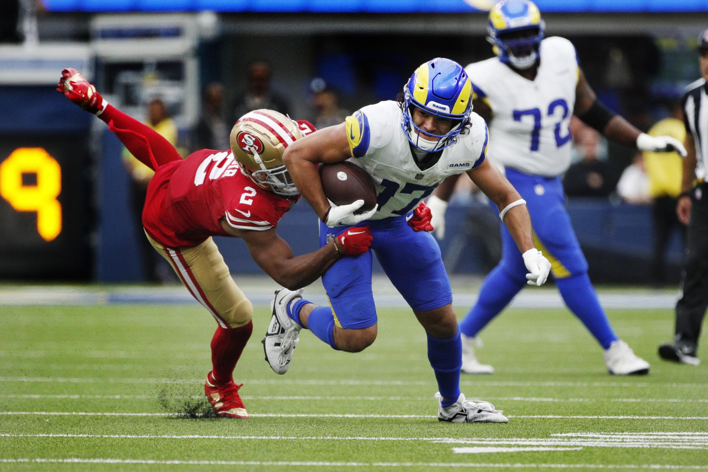 San Francisco 49ers cornerback Deommodore Lenoir (2) tackles Rams' receiver Puka Nacua after a reception in Week 2.