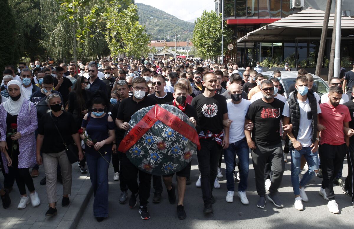 People march in silence to honor the victims in the burned out makeshift hospital in North Macedonia's northwestern town of Tetovo, Saturday, Sept. 11, 2021. Hundreds of people have marched Saturday in northwestern town of Tetovo to honor their 14 countrymen killed in a deadly fire that broke earlier this week and destroyed COVID-19 field hospital. (AP Photo/Boris Grdanoski)