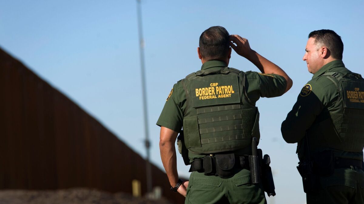 United States Border Patrol agents stand near a section of the recently renovated US-Mexico border wall, in Calexico, California, USA, on 26 October 2018.