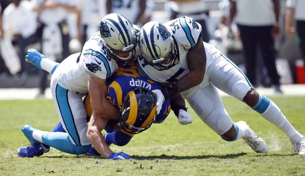 Rams wide receiver Cooper Kupp, bottom, is tackled by Carolina Panthers linebackers Luke Kuechly, left, and Shaq Thompson.