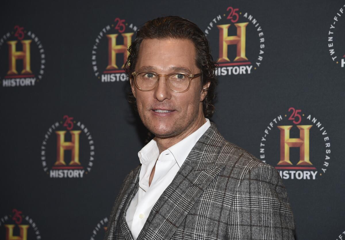 Matthew McConaughey wearing a black and white blazer, white shirt and glasses at red carpet event