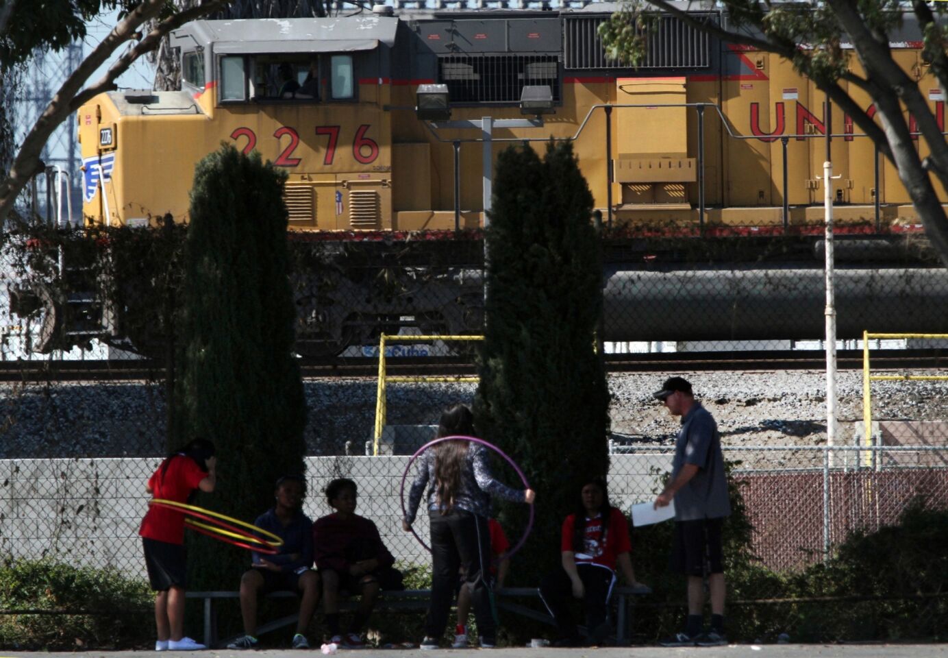 Hudson Elementary phys ed teacher Rob Aho conducts his class as a Union Pacific engine pulls its load along the tracks across from the school.