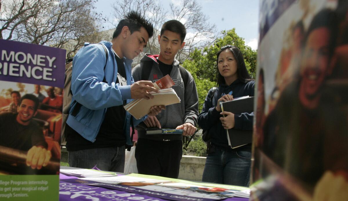 Cal State Fullerton students check out the Disneyland job fair booth. Stubbornly high jobless rates among young people are costing the U.S. billions a year in uncollected taxes and extra safety net benefits.