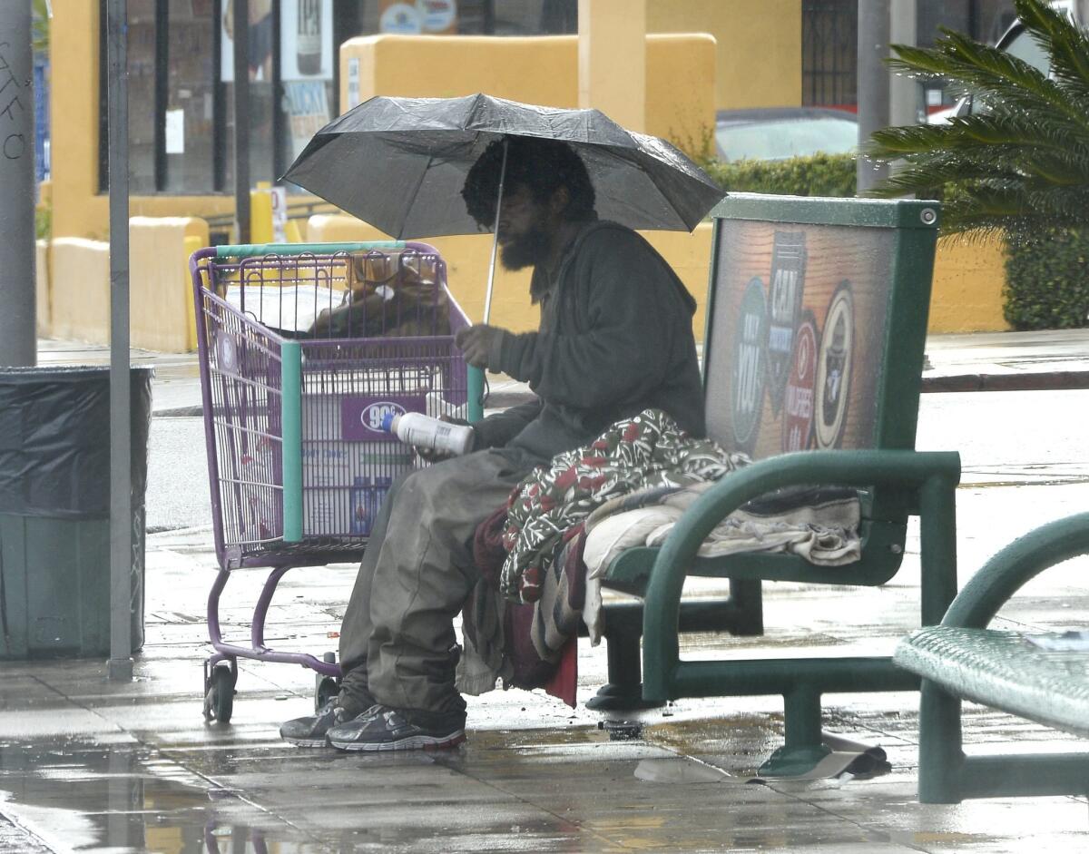 A homeless man sits at a bus stop in Los Angeles on Jan. 5.