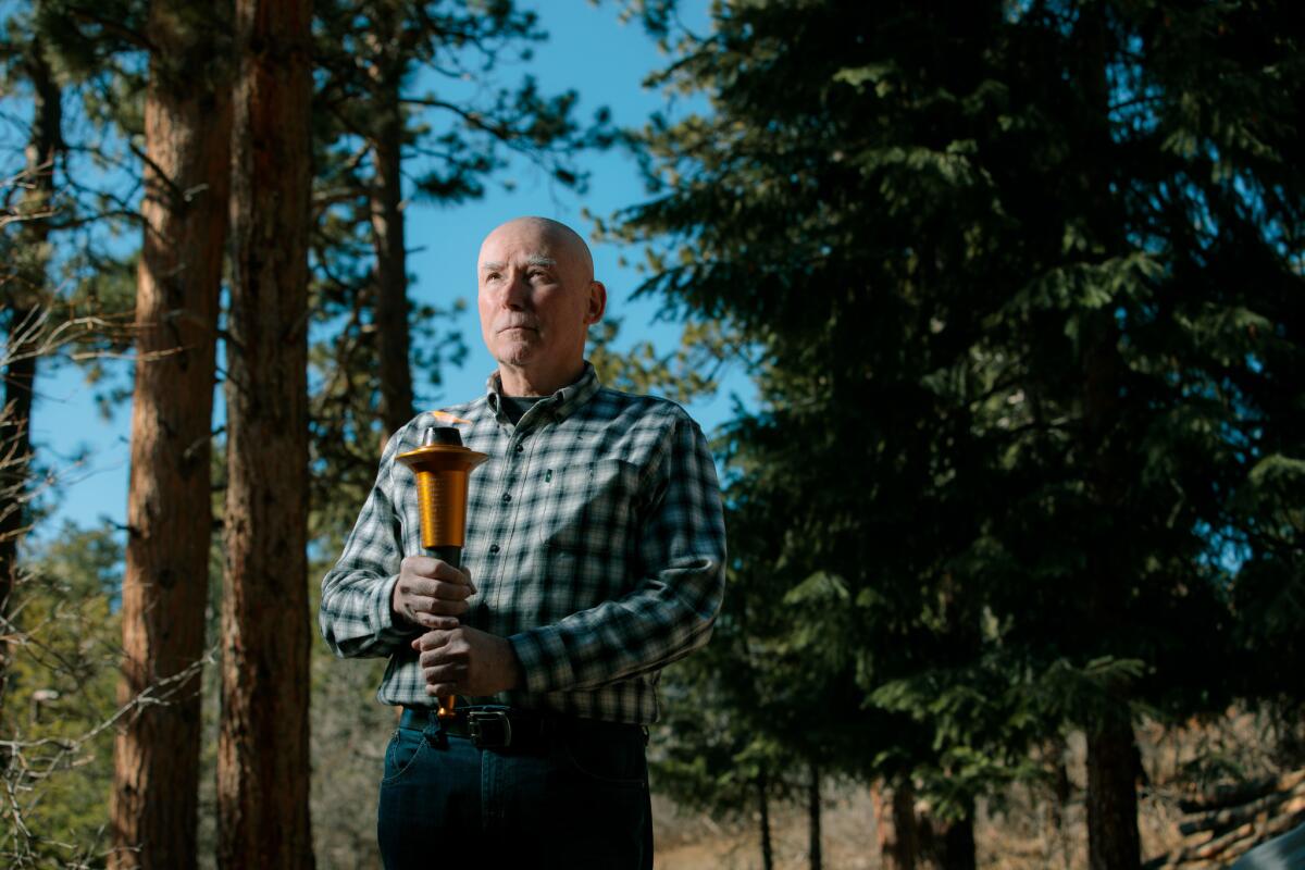 Pastor Bruce Porter holds a torch he uses at speaking engagements. At the 1999 funeral of Rachel Scott, he urged mourners to pick up the torch of goodness Rachel left behind when she was killed at Columbine.