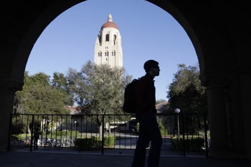 FILE - In this Feb. 15, 2012 file photo, a Stanford University student walks in front of Hoover Tower on the Stanford University campus in Palo Alto, Calif. Congressional inaction could end up costing college students an extra $5,000 on their new loans. The rate for subsidized Stafford loans is set to increase from 3.4 percent to 6.8 percent on July 1, just as millions of new college students start signing up for fall courses. The difference between the two rates adds up to $6 billion. (AP Photo