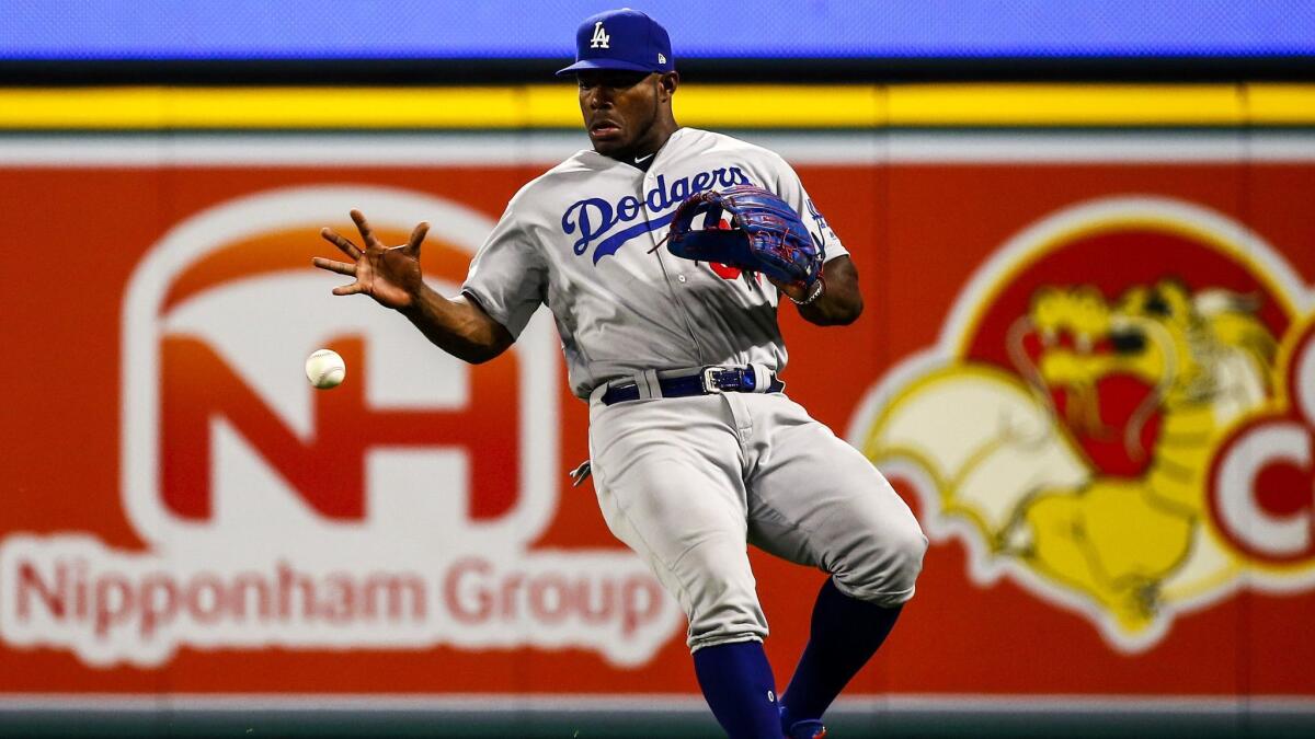 Dodgers right fielder Yasiel Puig (66) reaches to grab a hit to right field by Angels second baseman Ian Kinsler (3) late in the ninth inning.