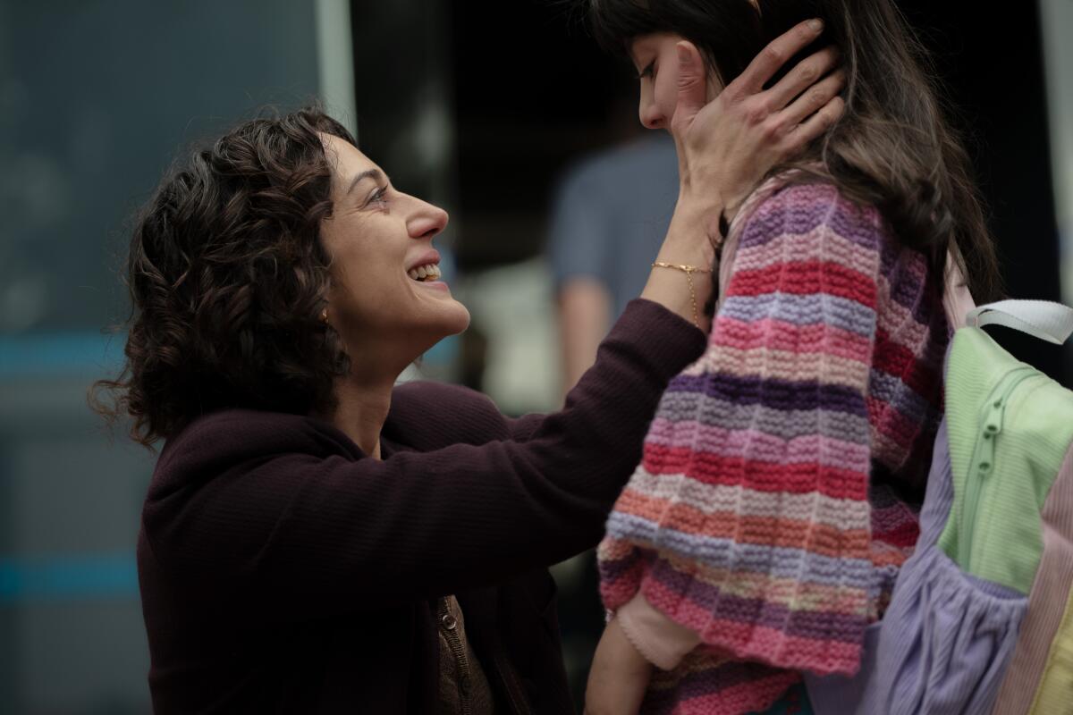 A woman smiles at her daughter.