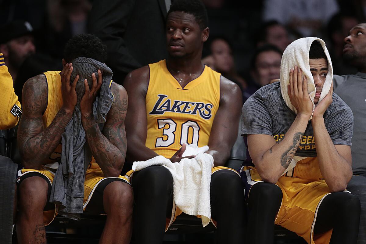 Lou Williams, Julius Randle and D'Angelo Russell sit on the bench during the final minutes of the Lakers' 112-93 loss to the Sacramento Kings on Jan. 20.