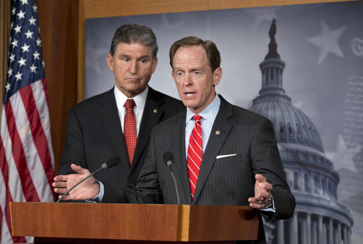 Democratic Sen. Joe Manchin III of West Virginia, left, and Republican Sen. Patrick J. Toomey of Pennsylvania talk about their proposal on expanding background checks to more gun buyers at the Capitol in Washington.