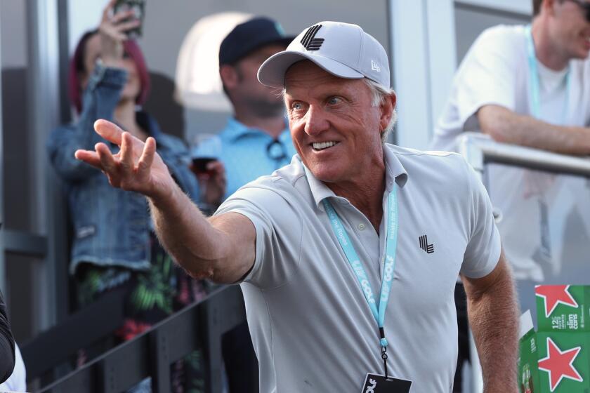 Greg Norman, CEO of LIV Golf, tosses a beer to spectators into the crowd surrounding the 18th green.