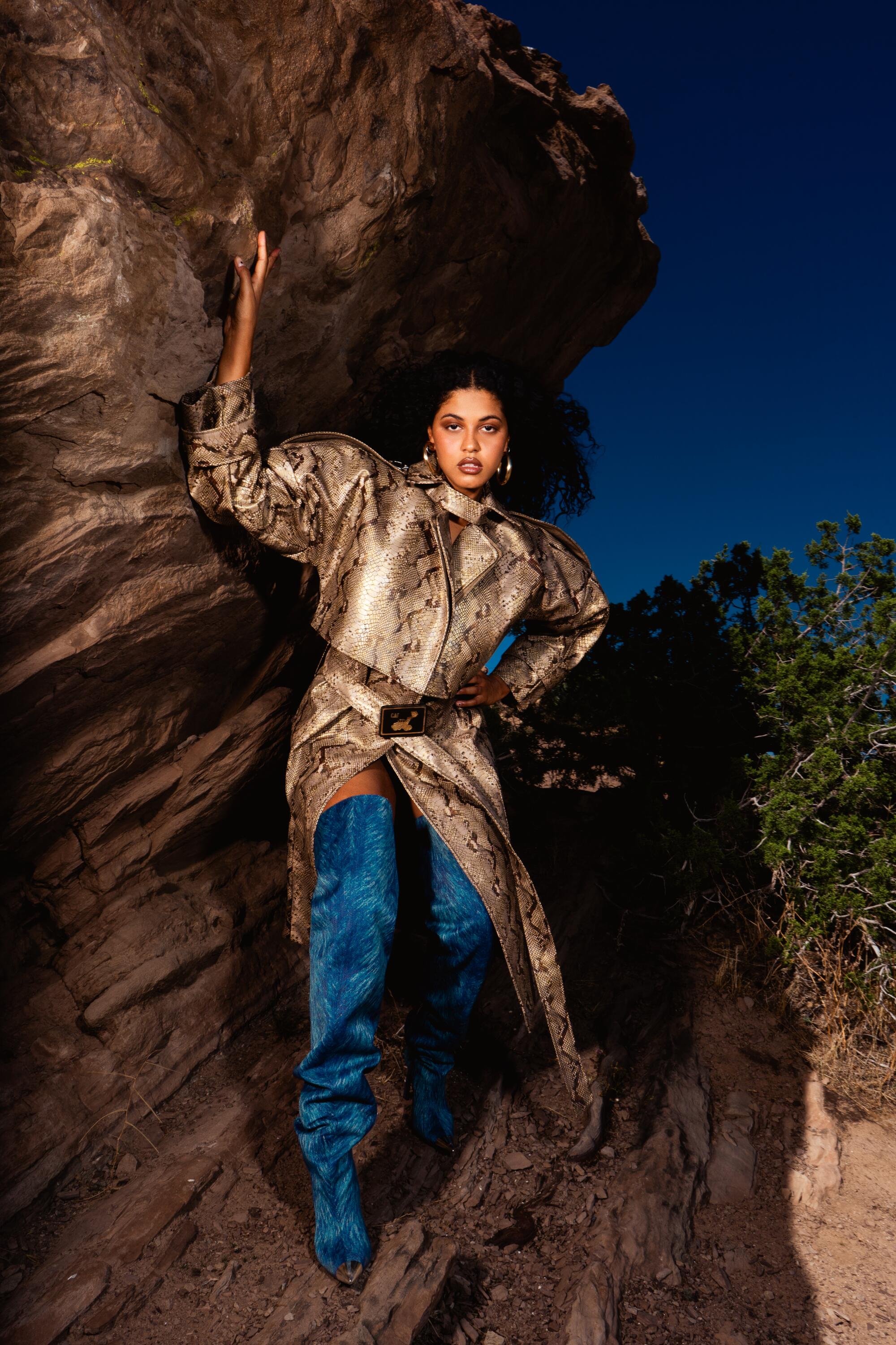 Yendry leans on boulders in the desert.