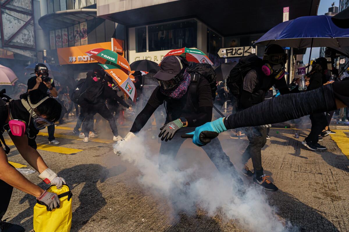 Protesters try to contain tear gas canisters in Hong Kong