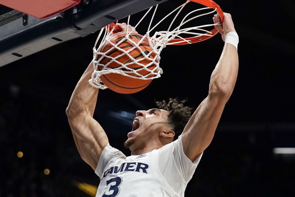 Xavier guard Colby Jones dunks during the first half of the team's NCAA college basketball game against Connecticut, Friday, Feb. 11, 2022, in Cincinnati. (AP Photo/Jeff Dean)
