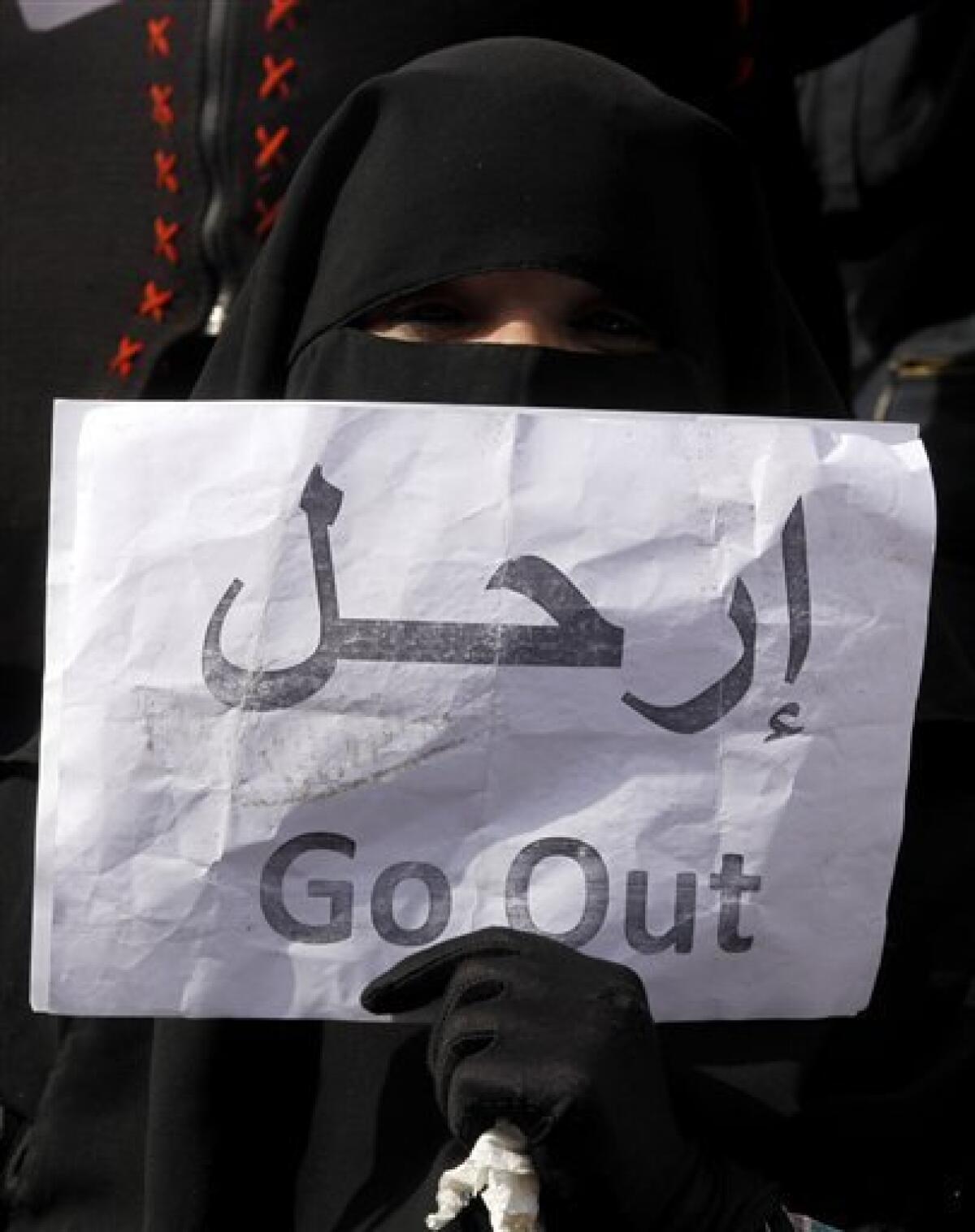 A veiled woman holds a poster calling for President Hosni Mubarak to go, in Tahrir, or Liberation, Square in Cairo, Egypt, Tuesday, Feb. 1, 2011. Tens of thousands of people flooded into the heart of Cairo Tuesday, filling the city's main square as a call for a million protesters was answered by the largest demonstration in a week of unceasing demands for President Hosni Mubarak to leave after nearly 30 years in power. (AP Photo/Victoria Hazou)