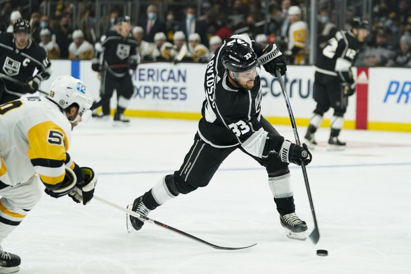 Los Angeles Kings' Viktor Arvidsson (33) shoots under pressure by Pittsburgh Penguins' Kris Letang.