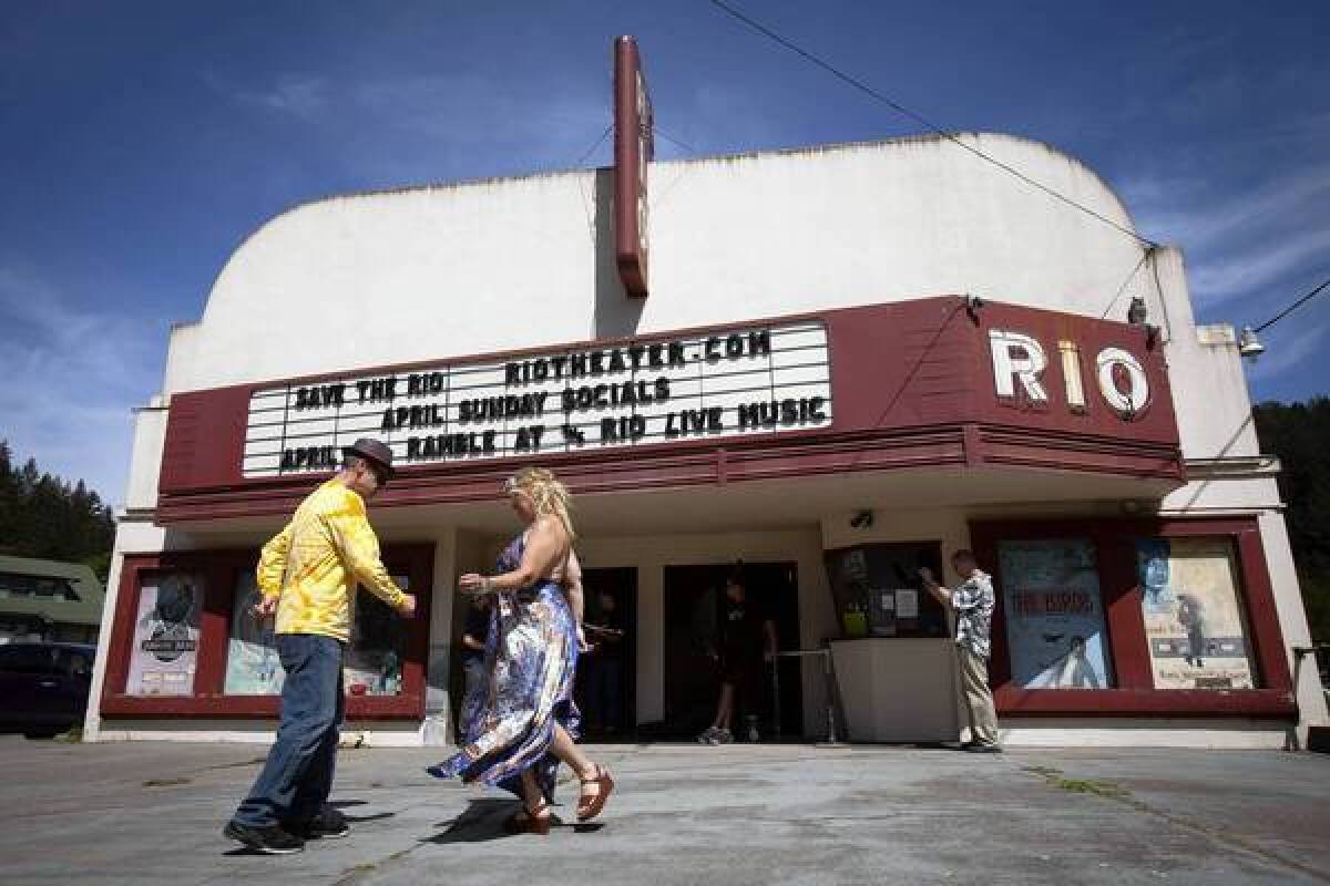 Robert Neir and Sage O'Connell dance to bluegrass music in front of the Rio Theater in Monte Rio, Calif., as musicians practice before a concert to raise funds for the historic theater.