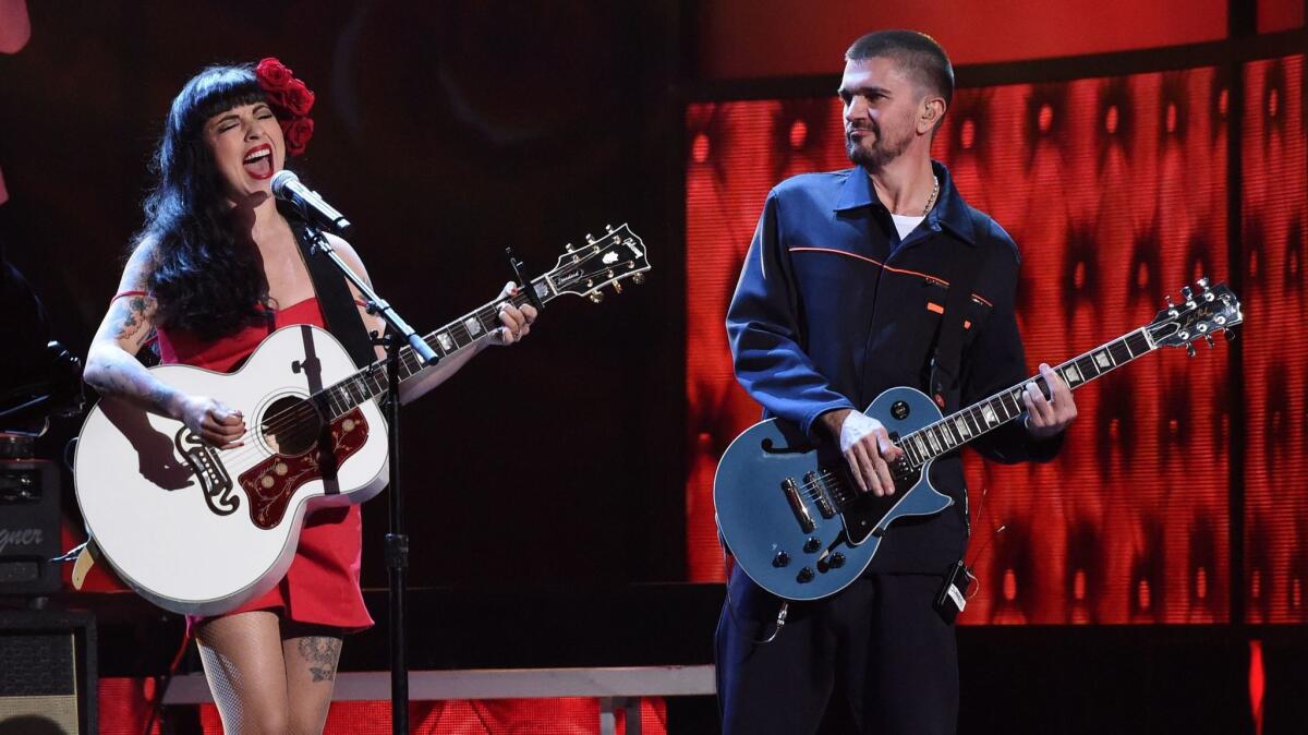 Chilean singer-songwriter Mon Laferte with Colombian pop star Juanes, accompanying her on guitar.