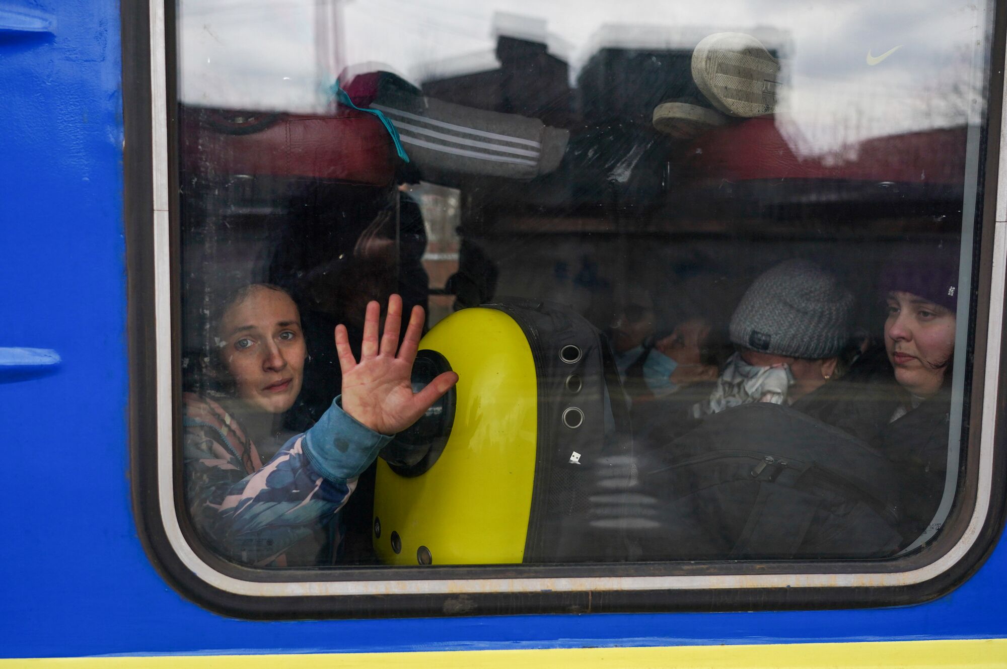 A train passenger presses a hand to the window