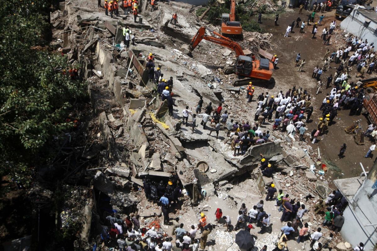 Rescue workers look for survivors and clear debris Friday at the site of a building that collapsed in Mumbai, India.