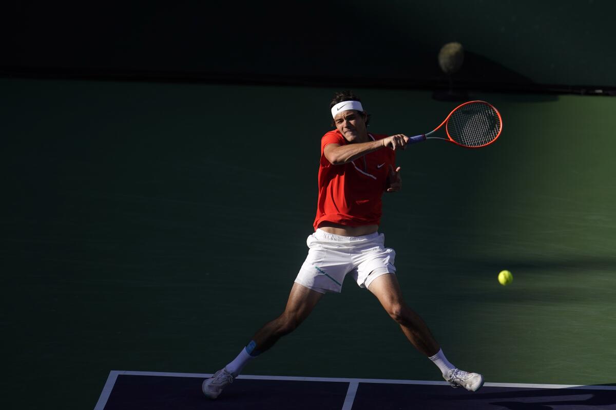 Taylor Fritz, here returning a shot, overcame an injury scare before the match to beat Rafael Nadal on Sunday.