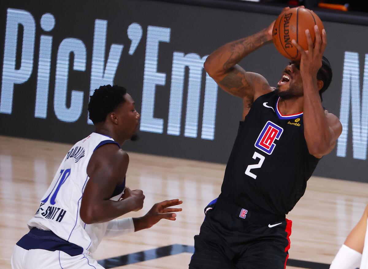 Clippers forward Kawhi Leonard draws a foul from Dallas Mavericks forward Dorian Finney-Smith during the second quarter.