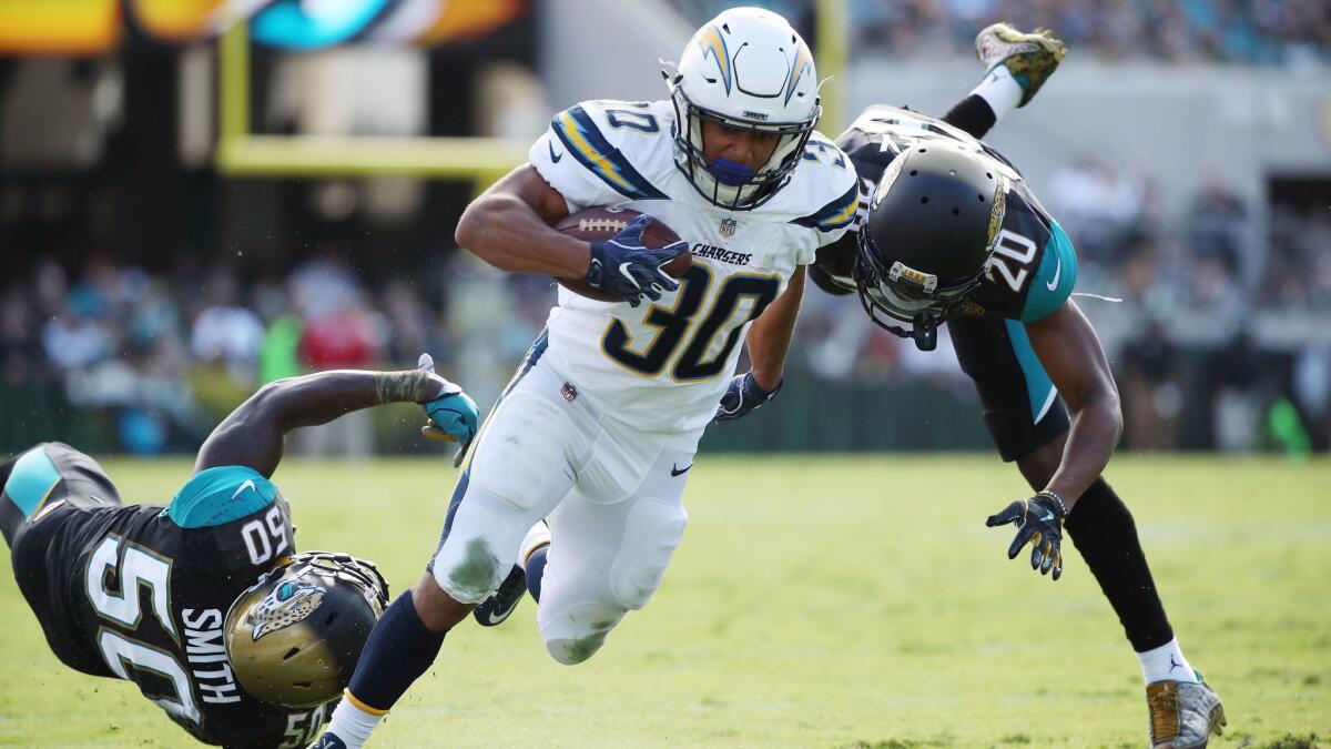 Austin Ekeler of the Chargers eludes the Jaguars' Telvin Smith, left, and Jalen Ramsey and scores a 28-yard touchdown in the first half.