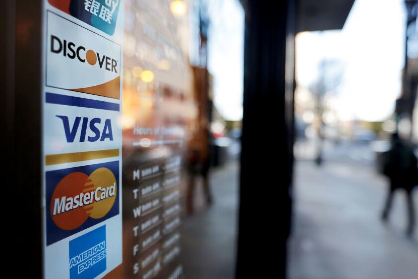 Credit card logos are posted to the door of a business in Atlanta, Wednesday, Jan. 31, 2018. Record-level credit card debt and fluctuating incomes create financial challenges for many American households, especially those with lower incomes. The effects may be felt especially keenly in black households, where historic and systemic racial discrimination has led to greater disparities in wealth and debt. (AP Photo/David Goldman)