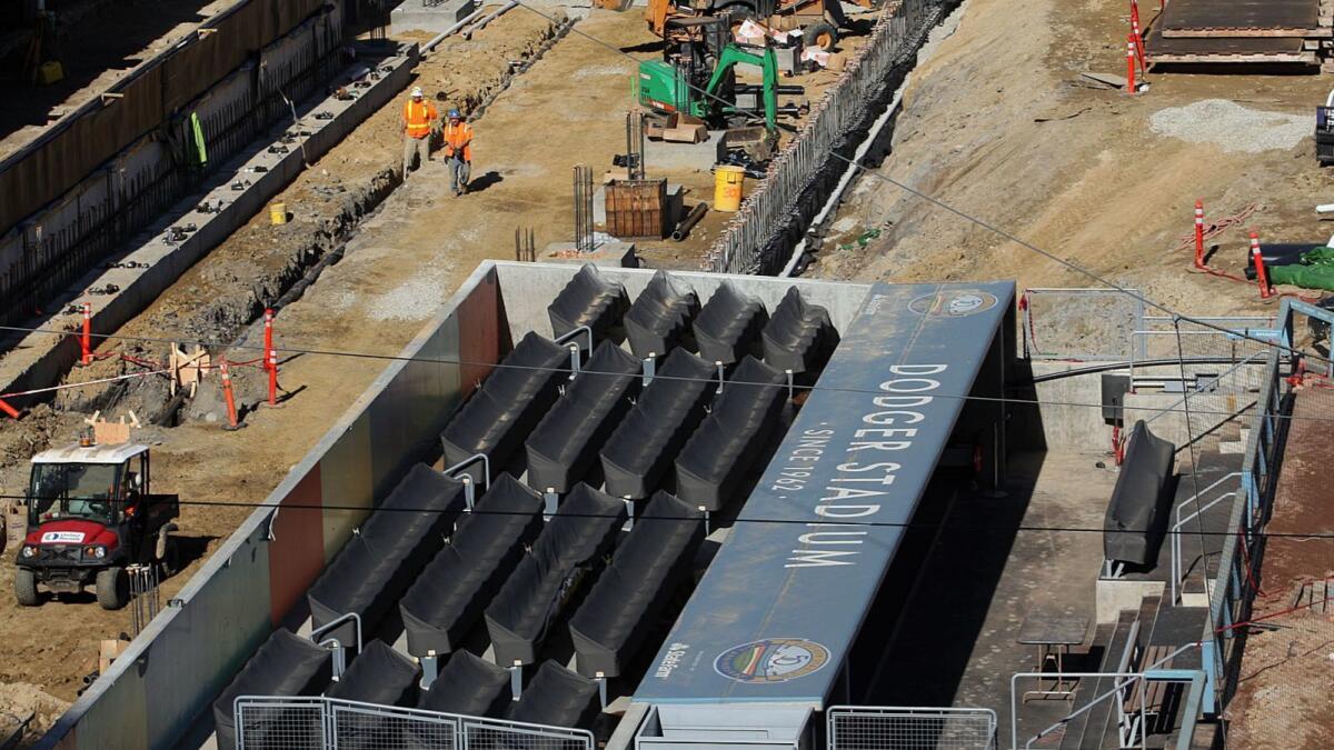 Construction workers excavate below an area of field-level seats during renovation at Dodger Stadium in January 2013.