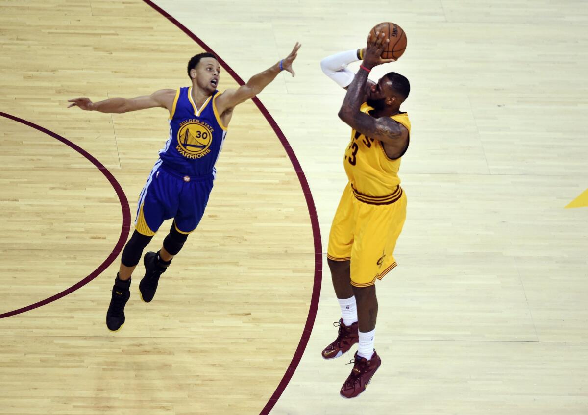 Cleveland Cavaliers' LeBron James shoots as Golden State Warriors' Stephen Curry defends during Game 4 of the 2015 NBA Finals.