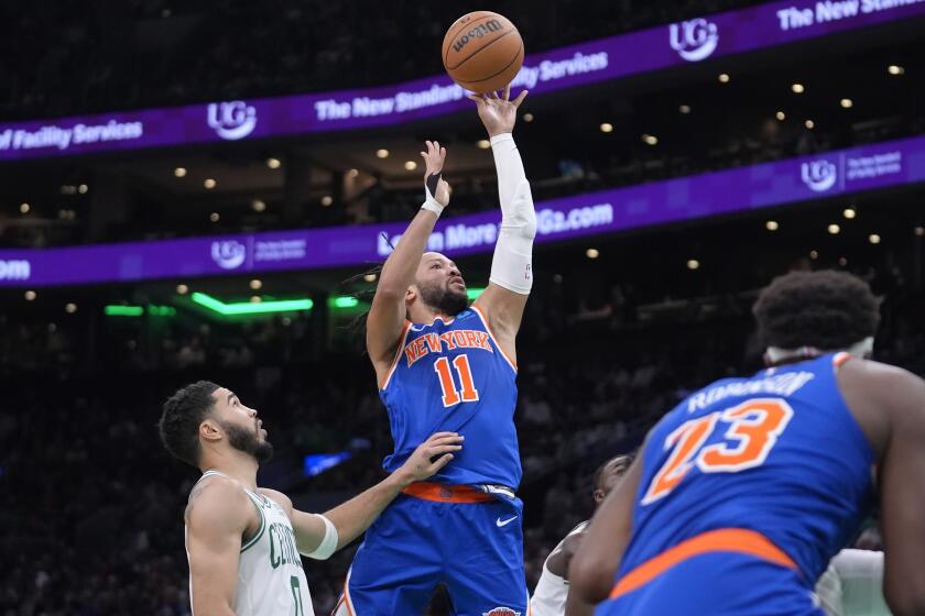 Jalen Brunson, base de los Knicks de Nueva York, dispara junto a Jayson Tatum, de los Celtics de Boston, el jueves 11 de abril de 2024 (AP Foto/Steven Senne)